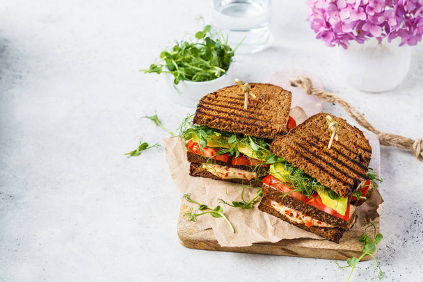 Vegan sandwich with tofu, hummus, avocado, tomato and sprouts. - Fotoğraf, Görsel