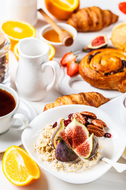 Mesa de desayuno con avena, croissants y frutas
.  - Foto, Imagen
