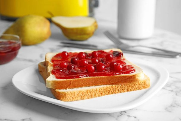 Slice of bread with jam on white marble table - Foto, imagen