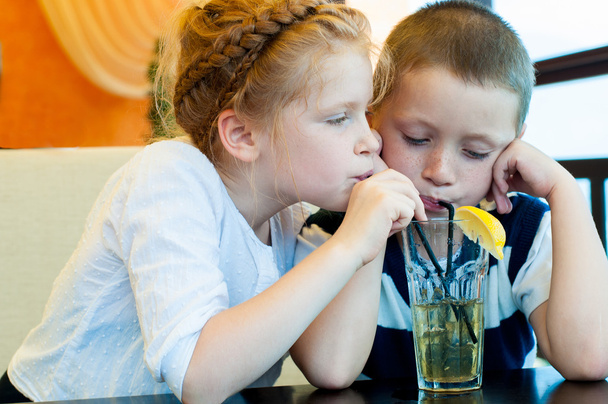 Boy and girl drinking a drink with ice through a straw - Foto, immagini