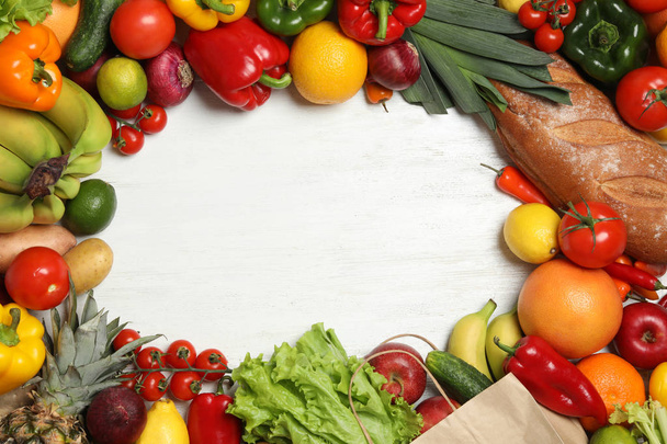 Πλαίσιο χαρτοσακούλα με φρέσκα λαχανικά και φρούτα σε λευκό ξύλινο φόντο, πάνω θέα. Χώρος για κείμενο - Φωτογραφία, εικόνα