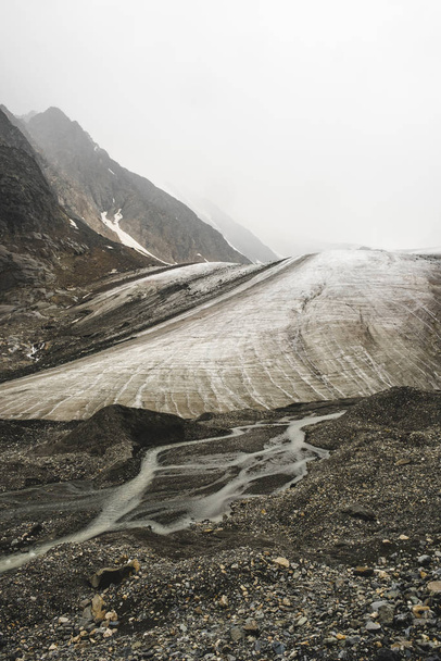 Majestueuze koude gletsjer in de bergen op weg naar de top van Aktru. Met sneeuw bedekte stenen hellingen. Rivier atmountains uitlopers. De ongerepte schoonheid van de natuur. Wandelen en bergbeklimmen. - Foto, afbeelding