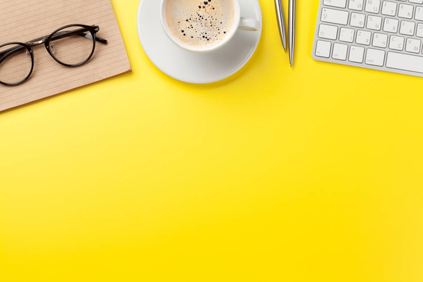 Büro gelber Hintergrund mit Kaffee, Vorräten und Computer - Foto, Bild