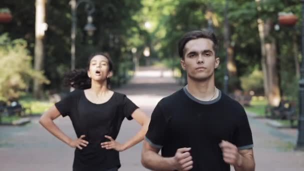 Young Man and Girl Running in the Park Girl Gets Tired and Stopped Man Continue Running Concept Healthy Lifestyle . - Séquence, vidéo