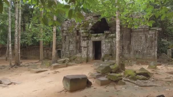 Pov:カンボジアの田舎にある美しい空の古代寺院への石の入り口に向かって歩く。静かな熱帯林でゆっくりと崩壊する息をのむような宗教的な建物に近づく映画のショット. - 映像、動画