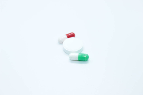 Multi-colored pill capsules are located on a white background - Foto, imagen