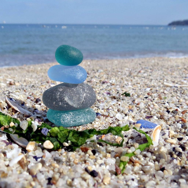Kolorowe szkło morskie na piasku plaży z Seascape tle. Plażowanie - Zdjęcie, obraz