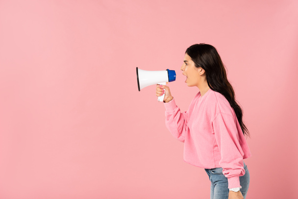 beautiful girl yelling into megaphone, isolated on pink - Photo, Image