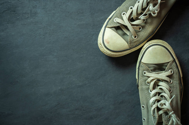 Sneaker sporca sul pavimento in cemento nero
. - Foto, immagini