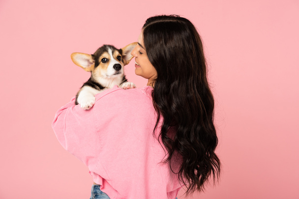 smiling woman holding cute puppy, isolated on pink - Fotoğraf, Görsel