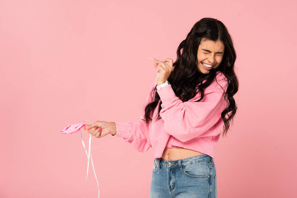 funny girl holding needle and pink balloon, isolated on pink - Photo, Image