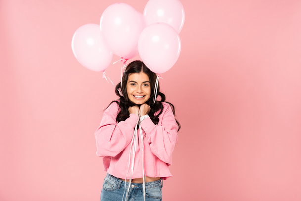 excited girl holding pink balloons, isolated on pink - Photo, Image