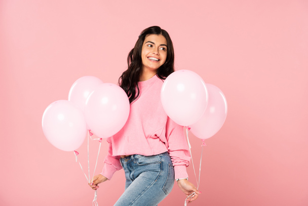 hermosa chica feliz sosteniendo globos de color rosa, aislado en rosa
 - Foto, imagen