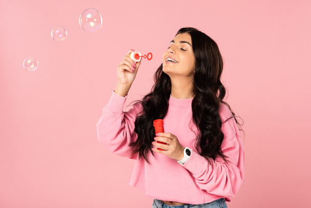 beautiful brunette girl blowing soap bubbles isolated on pink - Photo, Image