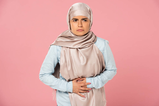 fille musulmane dans le hijab ayant mal au ventre, isolé sur rose
 - Photo, image