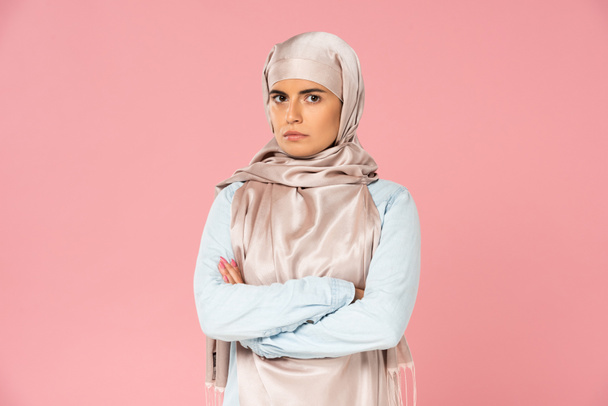 beautiful pensive muslim woman in hijab with crossed arms, isolated on pink  - Foto, afbeelding