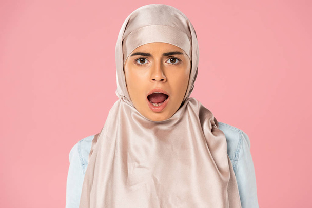 σοκαρισμένος μουσουλμάνος κορίτσι σε χιτζάμπ με ανοιχτό στόμα, απομονωμένο σε ροζ - Φωτογραφία, εικόνα