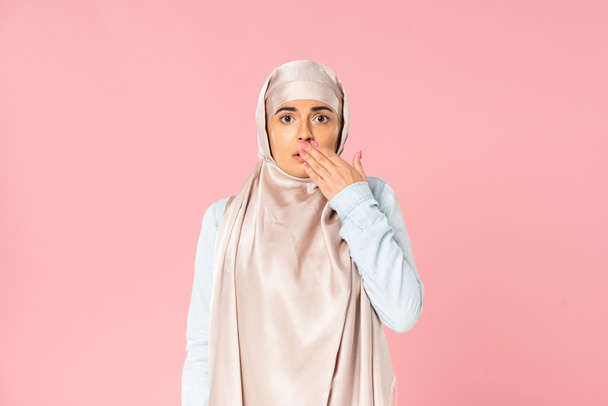 geschokt moslim vrouw in hijab gesturing, geïsoleerd op roze  - Foto, afbeelding