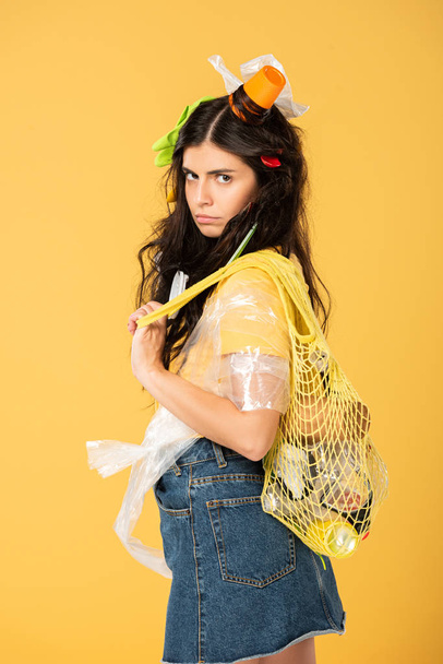 upset young woman with rubbish in hair isolated on yellow - Foto, Imagen