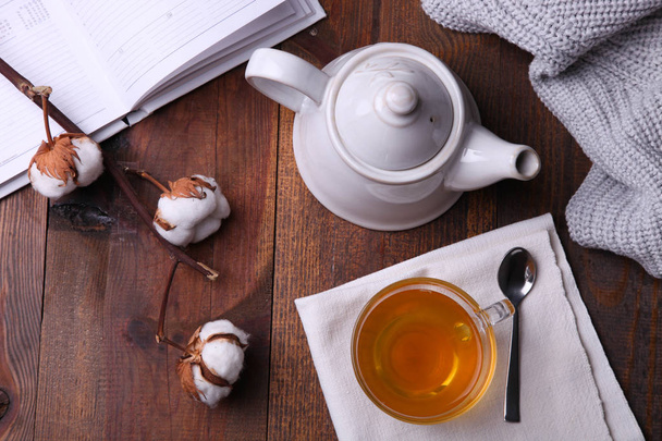 Чайник, чашка гарячого чаю і блокнот з плед
  - Фото, зображення