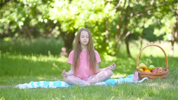 Kislány jóga pozícióban a parkban. - Felvétel, videó