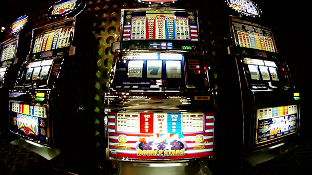Number of slot machines, man presses button on slot machine in center - Footage, Video