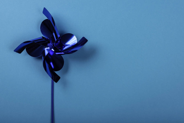 Blue pinwheel on blue background. Space for text on the right side of the image. - Foto, imagen