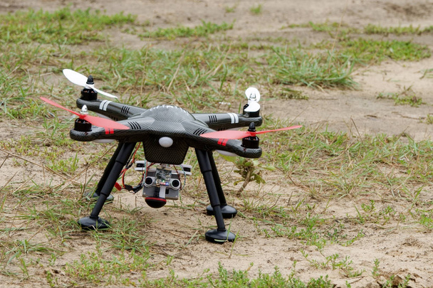 Eine Drohne ist flugbereit und schwebte vor dem Rennen über dem Boden. - Foto, Bild