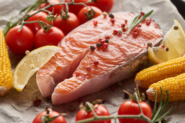 raw fresh salmon with spices, lemon, corn and tomatoes - Photo, Image