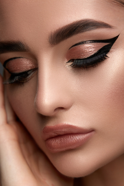Luxus-Make-up für Frauen mit goldenem Schatten und schwarzen Eyelinern mit perfekten Brauen  - Foto, Bild