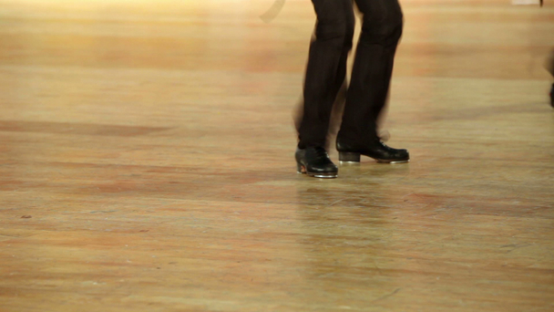 Einige Jungen in Schuhen mit Steppschuhen und schwarzen Hosen tanzen Stepptanz - Filmmaterial, Video