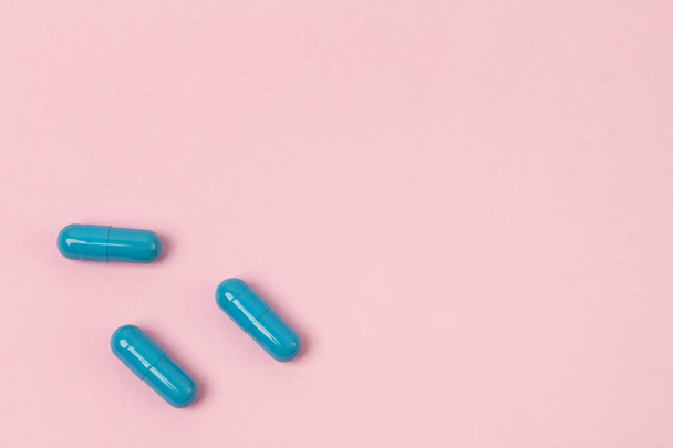 Blue pills at pink background.Flat lay. Empty place for text. - Fotó, kép