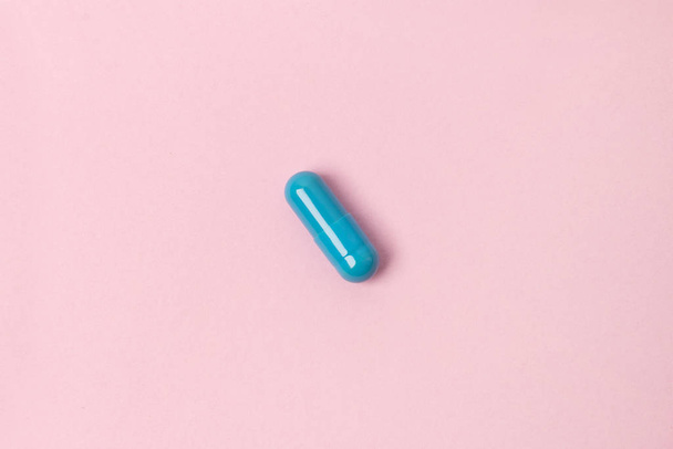 Blue pill at pink background. Flat lay top view. - Photo, Image