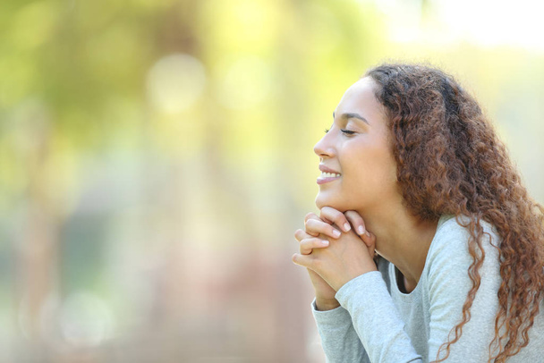 Happy mixed race woman meditating outdoors - Фото, зображення