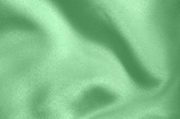 柔らかいドレープ生地のトレンディなミント色の背景。服やカーテンを作るための美しいサタンシルクのテクスチャー布。テキスタイルの背景テクスチャ. - 写真・画像