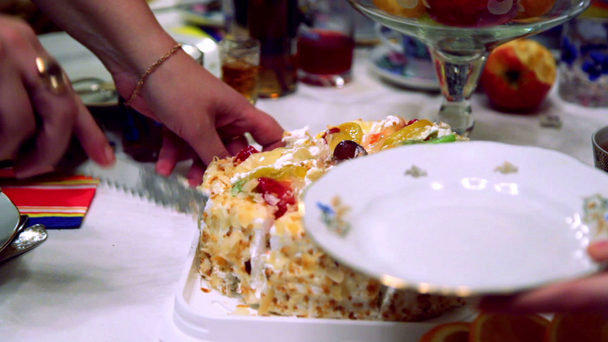 Mãos corta bolo de frutas doces por faca e colocar peça no prato
 - Filmagem, Vídeo