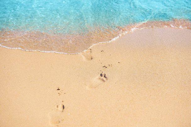 Modrá voda, měkký zlatý písek a stopy na písku. - Fotografie, Obrázek