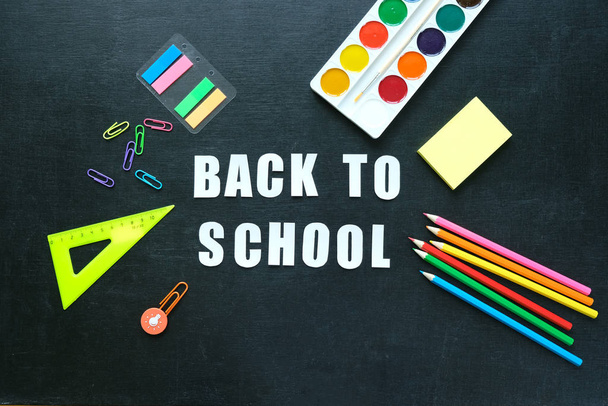 School supplies on blackboard background. Back to school concept - Photo, image