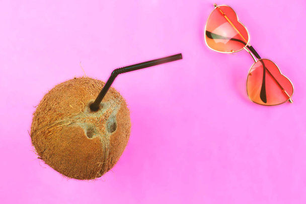 Kokosový ořech s černou slámou na neonové jasně růžové pozadí ve stylu webpunku v odpařovku, vrcholový pohled s volnou kopií pro text. Letní koncept tropický byt. Módní minimalismus surrealismus v ovoci  - Fotografie, Obrázek