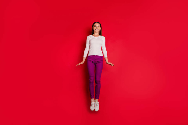 Photo of cool nice cute charming girl jumping up flying like rocket while isolated with red background - Foto, immagini