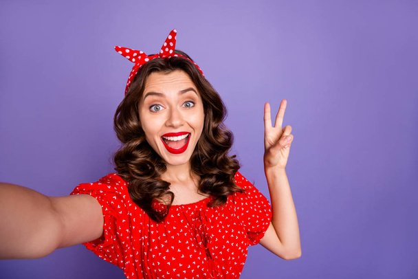 Closeup photo of pretty lady making selfies showing v-sign symbol wear red dress isolated purple background - Φωτογραφία, εικόνα