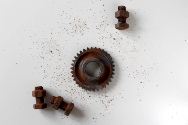 Rozsdás csavar, dió és fogaskerék a csokoládéval izolált csokoládé fehér alapon - Fotó, kép