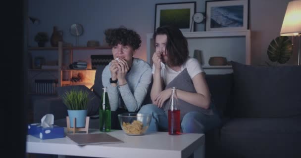 Crying women watching sad show on TV wiping eyes with paper tissue at night - Filmagem, Vídeo