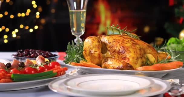Geroosterde kip klaar om te worden geserveerd op kerst feestelijke tafel met Champagne in de buurt van kerstboom en open haard. Dolly shot 4k - Video