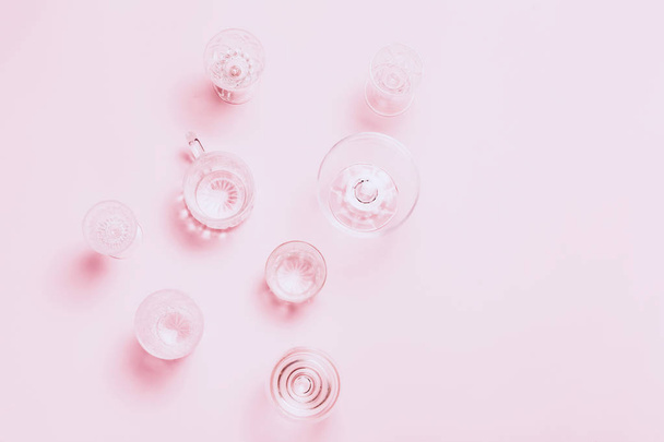 Many empty glasses on pink background. Top view, flat lay. - 写真・画像