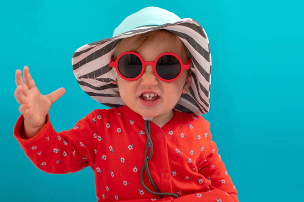 Stylish playful kid in sunglasses and striped hat - Photo, Image