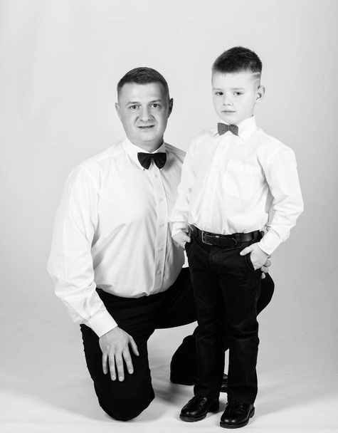 Grow up gentleman. Dad and boy with bow ties. Gentleman upbringing. Formal event. Little son following fathers example of noble man. Gentleman upbringing. Father and son formal clothes outfit - Foto, afbeelding