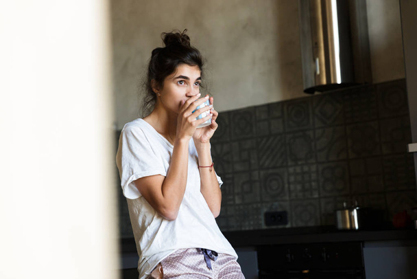 Photo of nice dreamy woman wearing home clothes drinking coffee in kitchen - Photo, Image