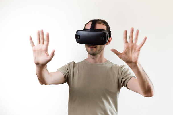 Člověk zkoumá moderní technologii virtuální realita s displejím namontovaného na bílém pozadí - Fotografie, Obrázek