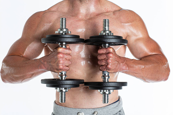 Close view of muscular man with naked torso and healthy tan working with dumbbells - Fotoğraf, Görsel